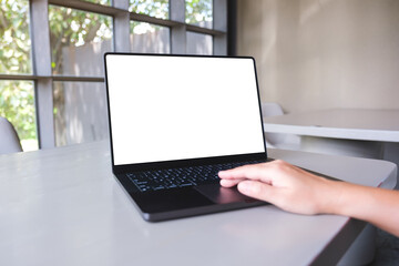 Mockup image of a woman working on laptop computer with blank white desktop screen