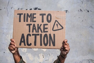 Hands Hold a Cardboard Sign That Reads 