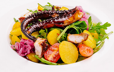 Colorful salad featuring octopus, arugula, and heirloom tomatoes in a bowl