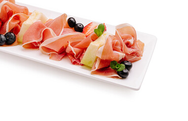 Delicious platter of cured meats and fresh fruits served elegantly