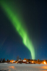 Northern lights glowing over Lapland’s snowy wilderness, a magical spectacle of nature’s beauty.