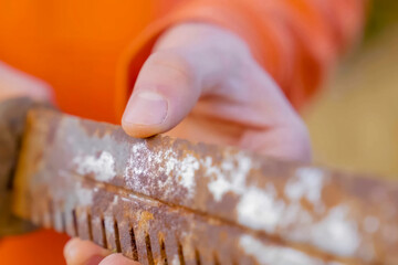 touching old rusty knife with his fingers.