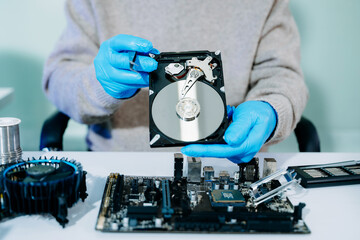  Hard disk drive on the technician's desk and a computer motherboard as a component. the concept of...