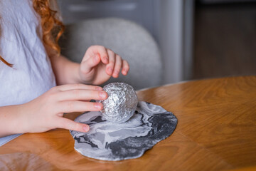 creative process, children teenage hands girls brushes mold from white and black airy plasticine a flat cake, rolls out on a wooden table