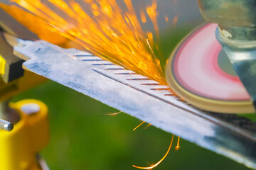 Obraz premium Grinding and polishing blade of a bayonet knife using a grinder disc