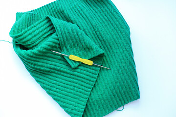 a beautifully crocheted green fabric set against a crisp white background. the intricate patterns and craftsmanship of the crochet work