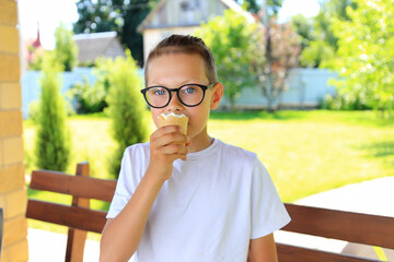 a teenager savoring a delicious ice cream cone while surrounded by the beauty of nature on a warm...
