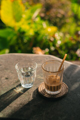 Delighting in a refreshing drink and coffee in a serene garden setting on a sunny day