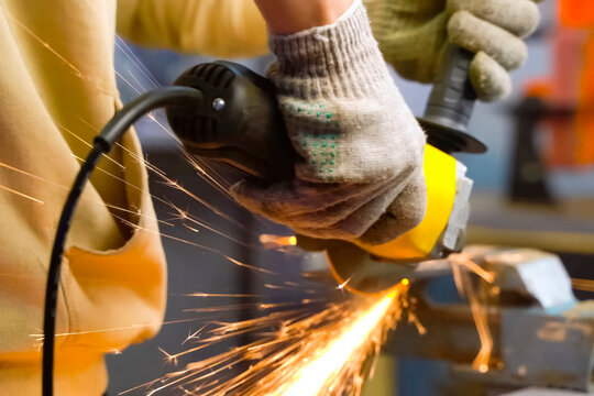 Grinding throwing knife in a vise using an angle grinder.