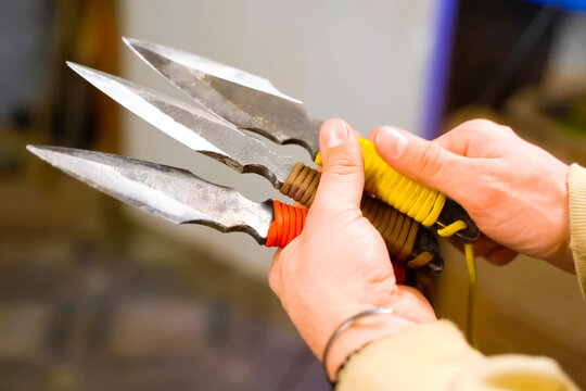 Throwing knife in hand aiming at target.