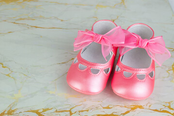 Close-up of adorable pink baby shoes with ribbons