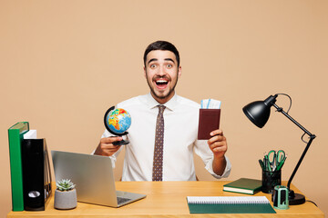 Young shocked traveler tourist employee business man wears white shirt sit work at office desk...
