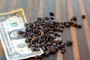 offee beans and dollar bill on wooden background