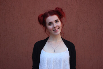 Young smiling woman in braces standing on a brown background