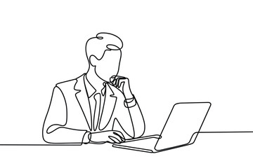 Businessman in suit working on laptop with hand on chin