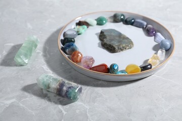 Many different healing stones on light grey table, closeup