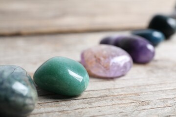 Many different healing stones on wooden table, closeup