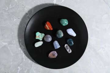 Many different healing stones on light grey table, top view