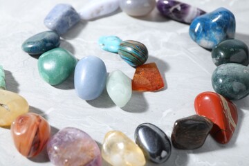 Many different healing stones on light grey table, closeup
