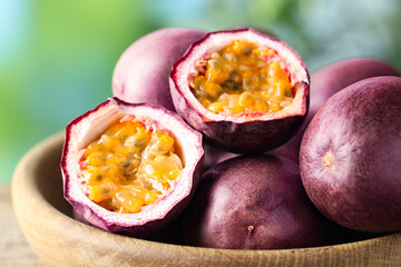Fresh passion fruits in bowl outdoors, closeup