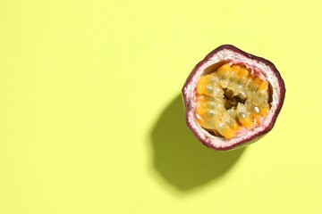 Half of fresh passion fruit on pale green background, top view. Space for text