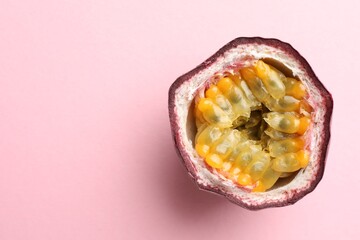 Half of fresh passion fruit on pink background, top view. Space for text