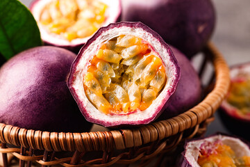 Fresh passion fruits in wicker basket on table, closeup