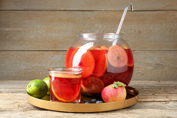 Tasty punch and fruits on wooden table. Refreshing drink