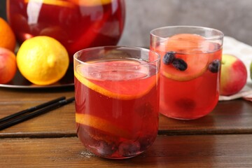 Tasty punch and fruits on wooden table, closeup. Refreshing drink