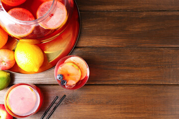 Tasty punch and fruits on wooden table, flat lay with space for text. Refreshing drink