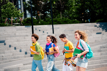 Happy group of diverse young college students enjoying time together on a sunny day outdoors
