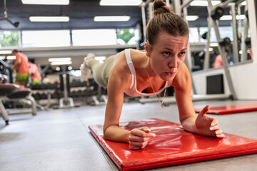  A young female is working out at the gym, focused and determined. She performs strength and cardio exercises with confidence, maintaining a healthy and active lifestyle in a fitness environment