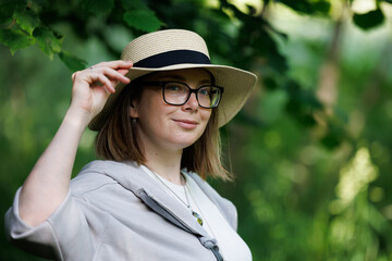 Woman wearing a straw hat in a lush green setting during daylight hours