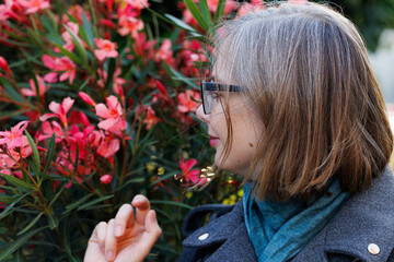 Fototapeta premium Woman enjoying spring flowers in a vibrant garden, immersed in the beauty of nature