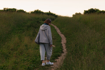 Walking along a grassy path during twilight in a peaceful outdoor setting
