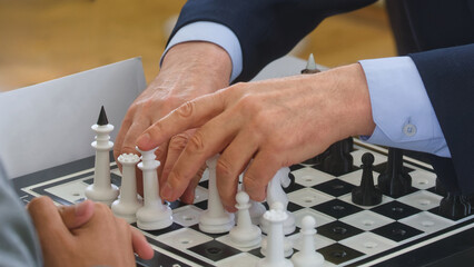 Blind grandmaster reads the position by touch on a tactile chessboard; hands feel raised pieces to...