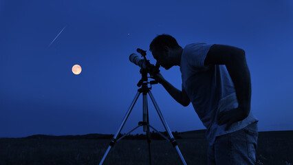 Amateur astronomer using telescope for watching stars, Moon, planets and other celestial objects...