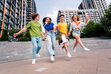 Group of youthful friends enjoying time together outdoors in the city on a bright day