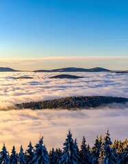 Snowy mountain peaks above a sea of clouds at dawn