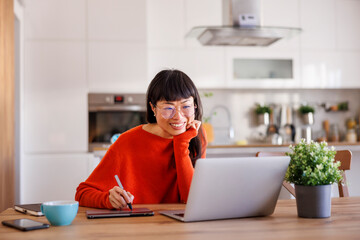 Web designer drawing using drawing pad while working remotely from home