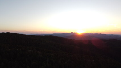 Obraz premium Sunset Over Mountain Range and Forest – Aerial View Landscape 
