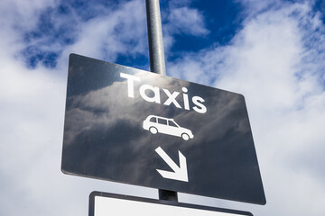 Taxi Rank Direction Sign with Arrow Against Blue Sky, Urban Transport Wayfinding