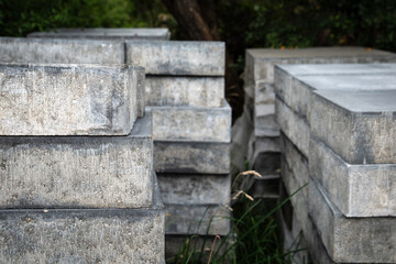 Detailed view of gray concrete paving blocks piled together, showing texture and durability, ready...