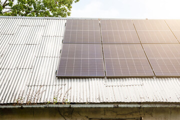 Modern solar panels mounted on an old corrugated metal roof, representing renewable energy, sustainable power, and eco-friendly technology