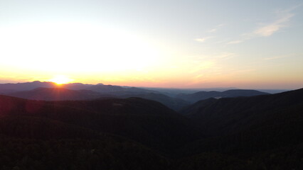 Sunset Over Mountain Range and Forest – Aerial View Landscape
