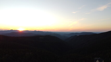 Sunset Over Mountain Range and Forest – Aerial View Landscape
