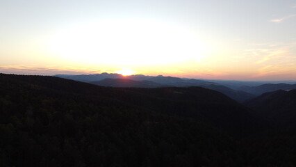 Sunset Over Mountain Range and Forest – Aerial View Landscape
