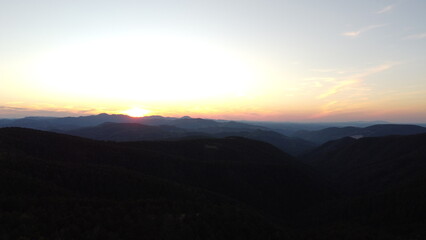 Sunset Over Mountain Range and Forest – Aerial View Landscape
