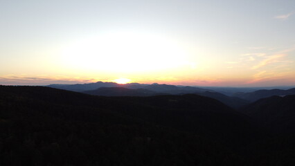 Sunset Over Mountain Range and Forest – Aerial View Landscape
