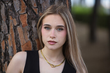 Portrait of a young, beautiful woman, blonde, with green eyes, wearing a black top, looking sweetly...